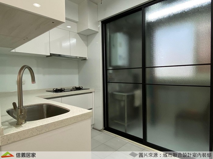 廚具選用抗菌的高級石英石檯面及櫻花L型廚具,全體櫥櫃面板則採用將壓克力色板貼附在基材上的結晶鋼烤,由於結晶鋼烤具有良好的抗潮性,且表面光滑容易清洗,不易吸附廚房油煙,是很好的廚具建材;陽台處同樣以玻璃拉門做出區隔,透過玻璃的通透性讓光線自然透入,明亮加大。