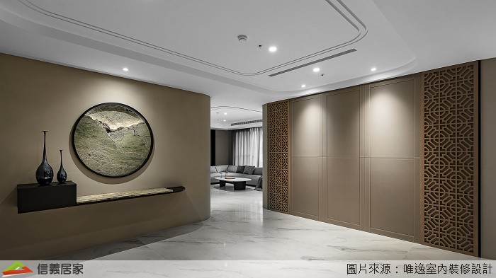 玄關牆面設計一面圓形窗景,透過光影的映照,在空間中重新架構組織輪廓,另一側設置隱藏收納櫃,讓居家收納隱形顯得美觀不繁雜。玄關主牆轉角處的圓弧形水墨風華,便是概念意化後落實的呼應,並展延至中島區域。